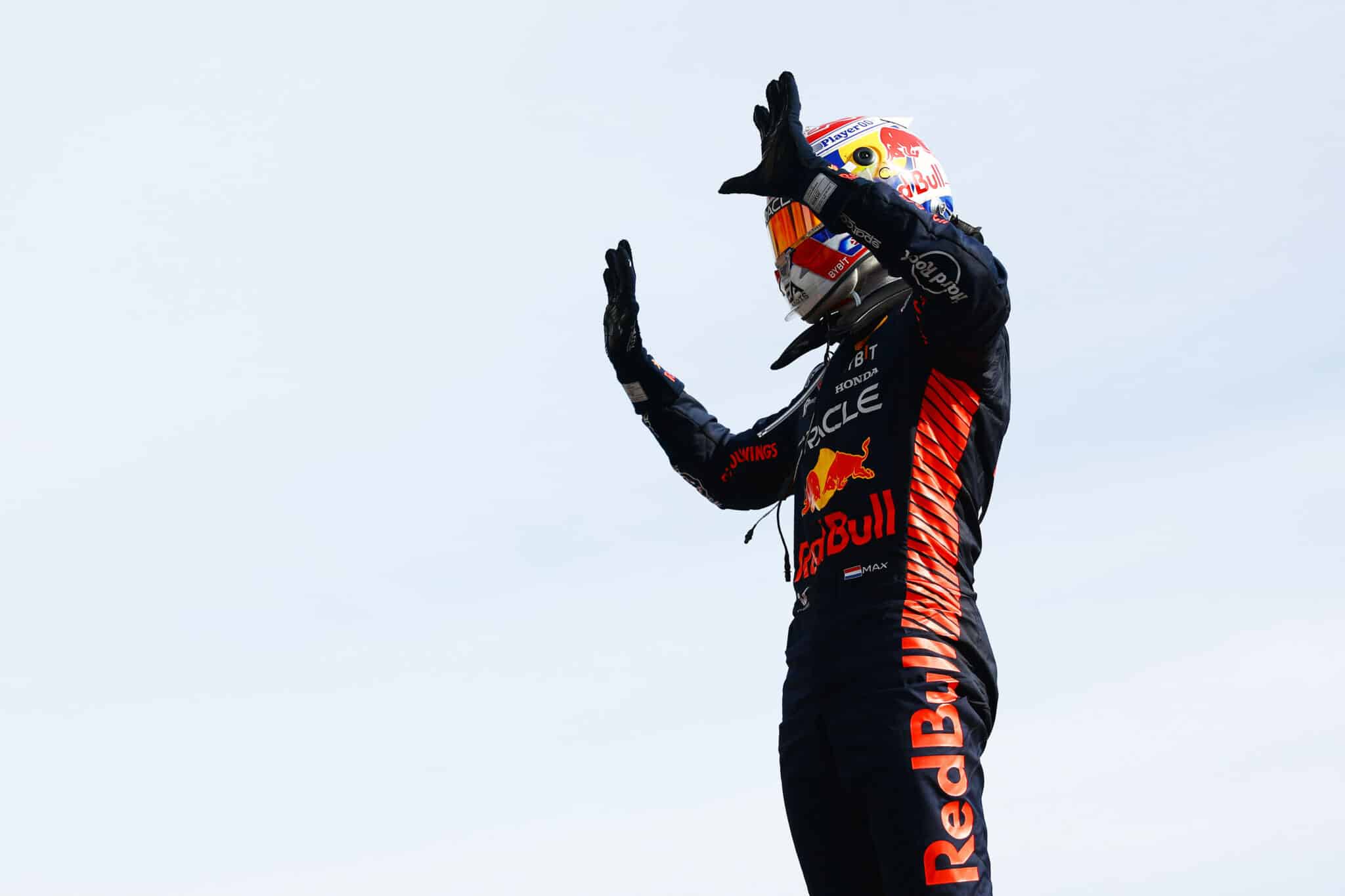 a man in a red bull racing suit waving