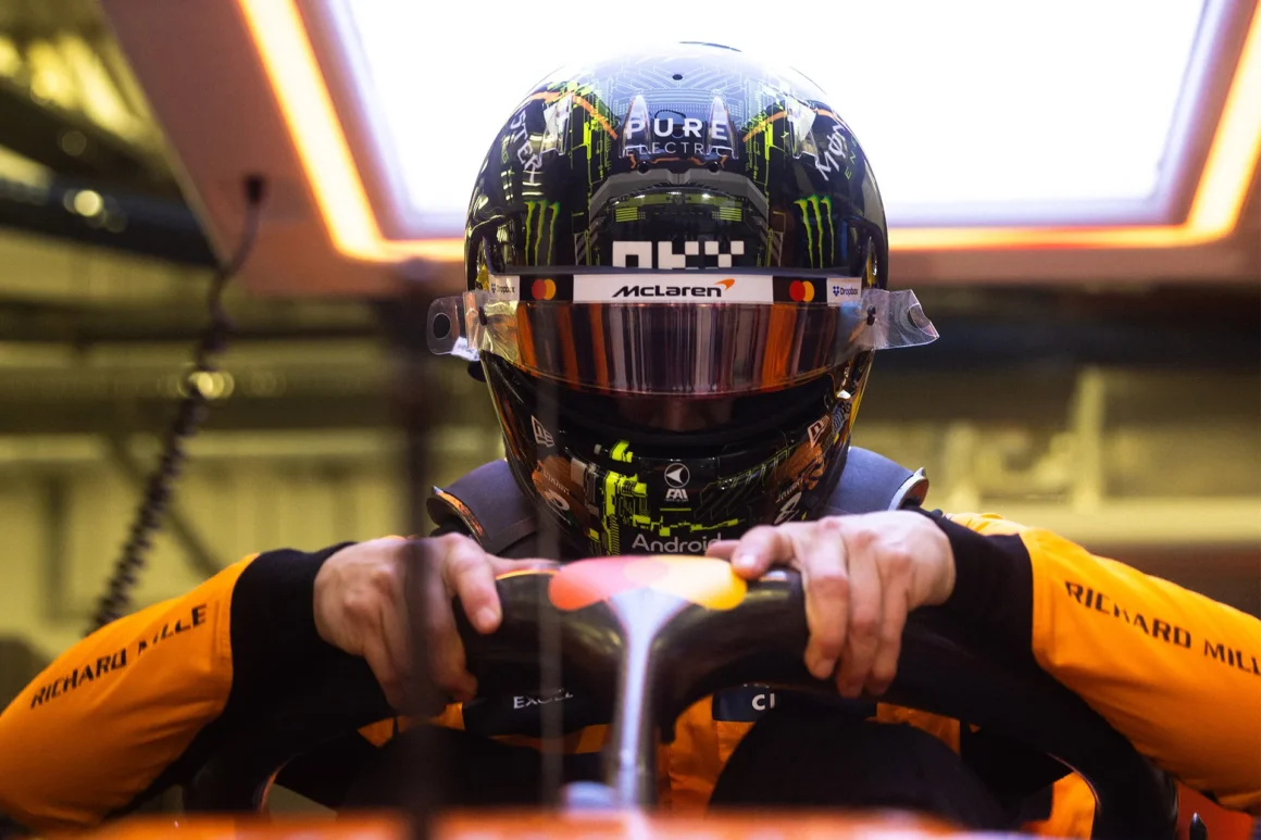 a man wearing a helmet and holding a steering wheel