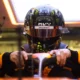 a man wearing a helmet and holding a steering wheel